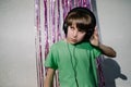 Young American boy wearing headphones near the purple confetti tapes - the concept of DJing