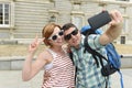 Young American couple enjoying Spain holiday trip taking selfie photo self portrait with mobile phone