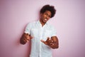 Young american man with afro hair wearing white shirt standing over isolated pink background disgusted expression, displeased and Royalty Free Stock Photo