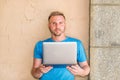 Young American Man with beard, reading, working on laptop computer outside in New York City Royalty Free Stock Photo