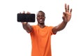 young american man experiencing joy and happiness demonstrating smartphone screen with mockup on white background with Royalty Free Stock Photo