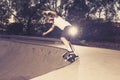 Young American man practicing radical skate board having fun enjoying tricks jumps and stunts in concrete half pipe skating track Royalty Free Stock Photo