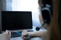 young american teen girl wear headphones video calling on laptop. pretty woman student looking at computer screen watching webinar Royalty Free Stock Photo