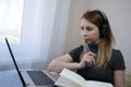 young american teen girl wear headphones video calling on laptop. pretty woman student looking at computer screen watching webinar Royalty Free Stock Photo