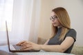 young american teen girl wear headphones video calling on laptop. pretty woman student looking at computer screen watching webinar Royalty Free Stock Photo