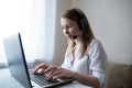 young american teen girl wear headphones video calling on laptop. pretty woman student looking at computer screen watching webinar Royalty Free Stock Photo