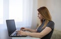 young american teen girl wear headphones video calling on laptop. pretty woman student looking at computer screen watching webinar Royalty Free Stock Photo