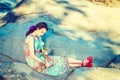 Young American Woman with white rose, sitting on rocks, relaxing Royalty Free Stock Photo