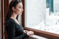 Young beautiful amused woman looking at store window in european town and choosing jewelry Royalty Free Stock Photo