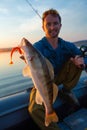 Young angler holds fish Royalty Free Stock Photo