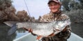 Young angler holds the trophy Asp fish Royalty Free Stock Photo