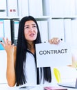 Young angry business woman ripping contract at the desk, break the rules - failure business concept.