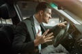 Young angry businessman sitts in his car looks anxious after hard day at workplace, stressfull working conditions concept Royalty Free Stock Photo