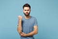 Young angry dissatisfied displeased man in casual clothes posing isolated on blue wall background, studio portrait