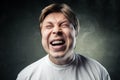 Young angry man over dark grey background Royalty Free Stock Photo