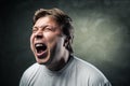 Young angry man over dark grey background Royalty Free Stock Photo