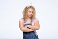 Young angry woman with curly hair and unicorn horn folded her arms