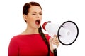 Young angry woman screaming through a megaphone