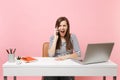 Young angry woman screaming talking on mobile phone while sitting and working on project at office with pc laptop Royalty Free Stock Photo