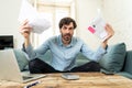 Angry man paying bills as home with laptop and calculator Royalty Free Stock Photo