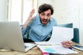 Angry man paying bills as home with laptop and calculator Royalty Free Stock Photo