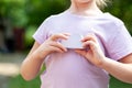 Young anonymous child, elementary school age girl holding a simple white cloud model in hands, object closeup, face obscured Cloud