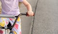 Young anonymous unrecognizable school age child riding an old used second hand bike, holding hands on handlebars closeup, detail,