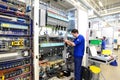 young apprentice assembles components and cables in a factory in a switch cabinet - workplace industry with future Royalty Free Stock Photo