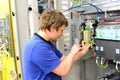 young apprentice assembles components and cables in a factory in a switch cabinet - workplace industry with future Royalty Free Stock Photo