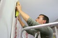 Young apprentice putting wallpaper Royalty Free Stock Photo