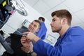 Young apprentice technician fixing office photocopier