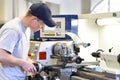 Young apprentice in vocational training working on a turning machine in the industry