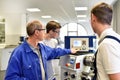 Young apprentices in technical vocational training are taught by older trainers on a cnc lathes machine Royalty Free Stock Photo