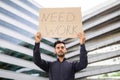 Young Arab businessman holding paper sign Need Work outdoors Royalty Free Stock Photo