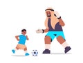 Young arab father playing football with son parenting fatherhood concept dad spending time with his kid Royalty Free Stock Photo