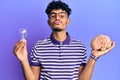 Young arab handsome man holding brain and lightbulb for inspiration and idea looking at the camera blowing a kiss being lovely and Royalty Free Stock Photo