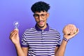 Young arab handsome man holding brain and lightbulb for inspiration and idea winking looking at the camera with sexy expression, Royalty Free Stock Photo