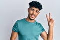 Young arab handsome man wearing casual clothes smiling with happy face winking at the camera doing victory sign Royalty Free Stock Photo