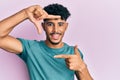 Young arab handsome man wearing casual clothes smiling making frame with hands and fingers with happy face