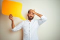 Young arab indian hispanic man holding speech bubble over isolated white background stressed with hand on head, shocked with shame Royalty Free Stock Photo