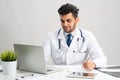 Young arab internist working at computer