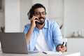 Young Arab Male Entrepreneur Talking On Cellphone And Taking Notes In Office Royalty Free Stock Photo
