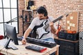 Young arab man artist compose song playing electrical guitar at music studio