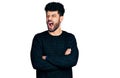 Young arab man with beard with arms crossed gesture angry and mad screaming frustrated and furious, shouting with anger Royalty Free Stock Photo