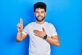 Young arab man with beard wearing casual white t shirt smiling swearing with hand on chest and fingers up, making a loyalty Royalty Free Stock Photo