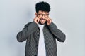 Young arab man with beard wearing glasses covering ears with fingers with annoyed expression for the noise of loud music Royalty Free Stock Photo