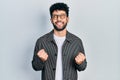 Young arab man with beard wearing glasses excited for success with arms raised and eyes closed celebrating victory smiling Royalty Free Stock Photo