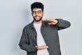 Young arab man with beard wearing glasses gesturing with hands showing big and large size sign, measure symbol Royalty Free Stock Photo