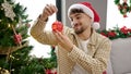 Young arab man decorating christmas tree at home Royalty Free Stock Photo