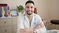 Young arab man doctor smiling confident sitting on table at clinic Royalty Free Stock Photo